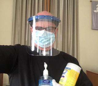 A man holding cleaning supplies during COVID-19