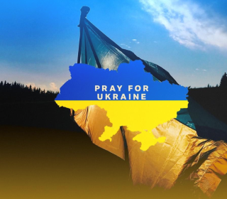 A map of Ukraine with the words Pray for Ukraine in white across it, against a background of the Ukrainian flag.