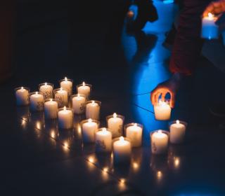 A row of lit votive candles in a church