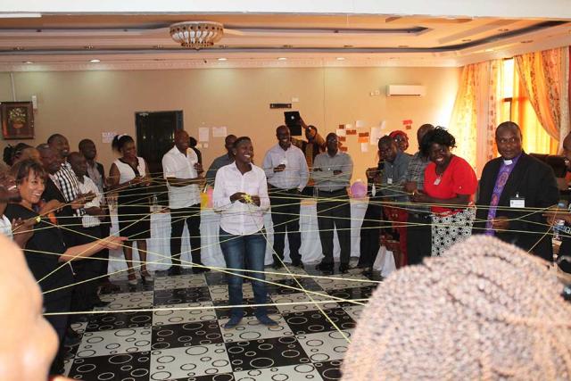 United Church and Zambian partners gather in a circle for a "string exercise" passing a ball of string to each other and forming a web that symbolizes connection.