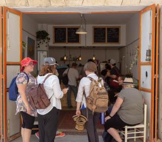 A group of young adult pilgrims from Canada gather in a doorway of a refugee-run cafe in Aida Refugee Camp.