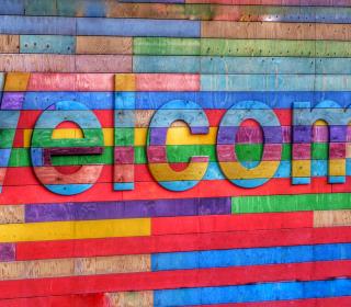 A multicoloured wooden sign spells out welcome