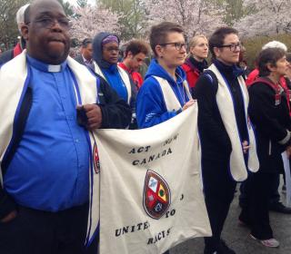 The author Paul Douglas Walfall (left) marches with the members of the United Church of Canada Delegation to the ACT March to End Racism carry a United Church banner at the event.