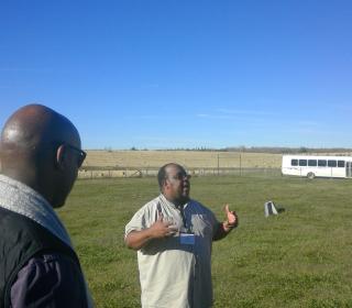 The author in the centre, leads a group of Black clergy on a visit to the cemetery at Amber Valley, AB.