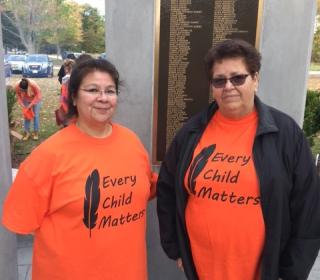 Two women display their "Every Child Matters" Orange T-shirts at Chippewa of the Thames First Nation ceremony.