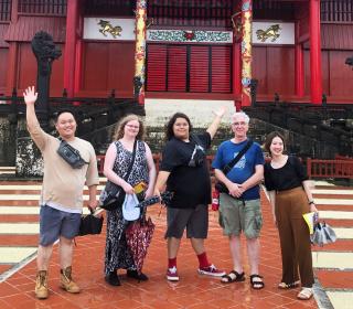Participants in the Minority Youth Forum, including two youth featured in this blog post (centre), pose for a group shot in front of a Japanese temple.