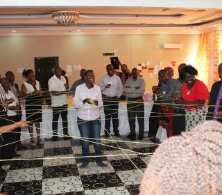 United Church and Zambian partners gather in a circle for a "string exercise" passing a ball of string to each other and forming a web that symbolizes connection.
