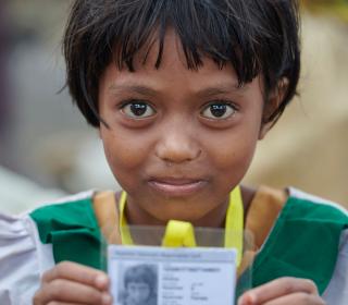 A Rohingya girl, having just crossed the border from Myanmar, shows her new identity card that she was given by United Nations workers in a refugee camp in Bangladesh.