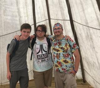 Three young men from the GC43 Pilgrims group pose together in a tepee while learning about the First Nations in the Saskatchewan area.