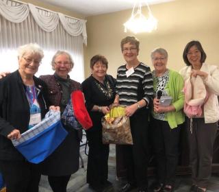 Author YoonOk Shin and the United Church Women of Alberta and Northwest Conference pose for a group shot with the shopping bags they sewed.
