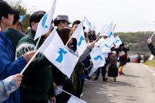 People gathered wave flags with a picture of a unified Korea and form a human peace chain in the Korean Peninsula