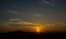 Sun rising over mountain range at dawn.