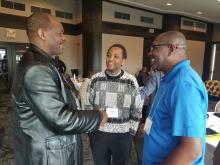 Three Black male clergy great each other at the United Church Black Clergy Gathering.