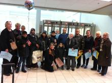 Author Bev McDonald (far right) pictured in a large group of people who welcomed a Syrian refugee family at Halifax Stanfield International Airport in December 2015.