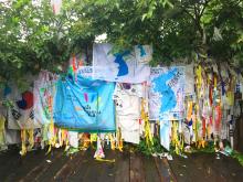 A peace memorial on the Korean DMZ stand with memory ribbons, maps, flowers, and other reminders of the call for peace.