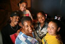 A mother with her family of five children - two boys and three girls - pose at home.