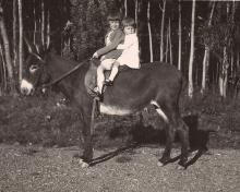 The mother for General Secretary Nora Sanders (closest to the front of the donkey) rides a donkey in Colombia, circa 1920.