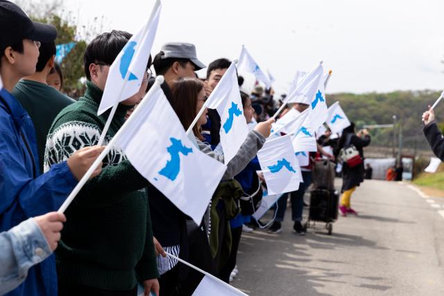 People gathered to form a human peace chain in the Korean Peninsula. People gathered wave flags with a picture of a unified Korea and form a human peace chain in the Korean Peninsula