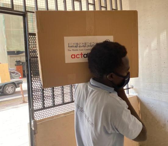 Relief worker carries a box of MECC relief items in Beirut