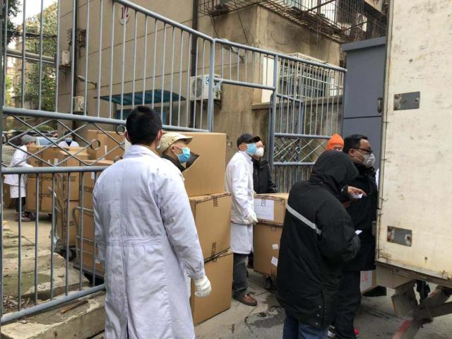 Arrival of medical supplies to Amity Foundation rescue operation of coronavirus relief in China. Photo of people unloading medical supplies from trucks in Wuhan, China