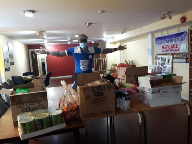 Adedeji, responsible for cultural integration of Nigerian refugees at Beaconsfield United Church, prepares to deliver food to newcomers. At Beaconsfield United Church, Adedeji prepares to deliver food to newcomers.