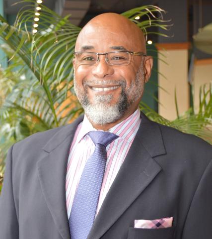 Rev. Dr. Bentley de Bardelaben-Phillips A portrait of Rev. Dr. Bentley de Bardelaben-Phillips, a Black man with glasses and a thin black and grey beard. He has a bright smile and is wearing a dark suit.