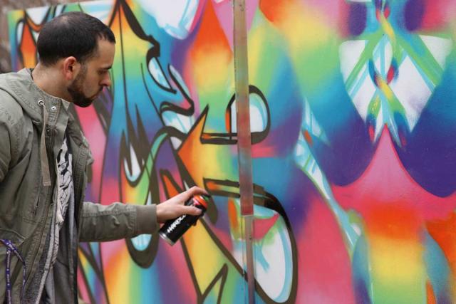 Graffiti artist Jeff Gasenzer creates a vividly coloured canvas at Crescent Fort Rouge United Church in April 2016. The church incorporates art in all its services during the 11-week arts festival. A graffiti artist paints a colourful scene at Crescent Fort Rogue United Church.