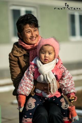 O Mi-Yang and her one-year-old daughter Bok-Ryan outside the Shimni Policlinic. Korean mother and baby