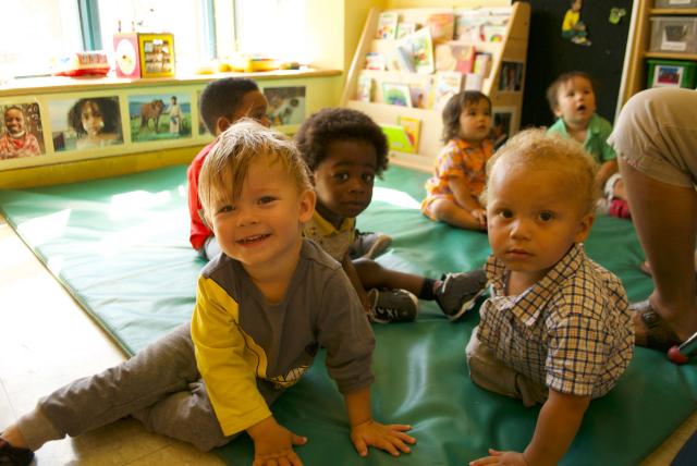 Children at the Massey Centre. A group of racially diverse toddlers play on a mat at Toronto's Massey Centre.